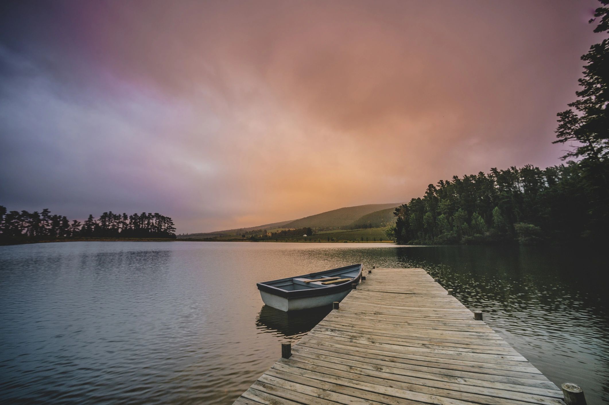 Wooden boat moored at a dock on a calm lake